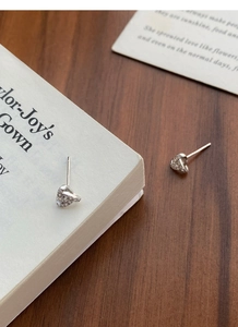 Close-up of heart-shaped S999 silver stud earrings with pavé set sparkling zircon stones