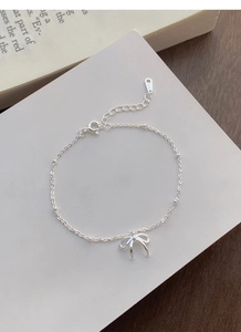 Dettaglio del bracciale in argento sterling S925 con ciondolo a fiocco e chiusura a moschettone