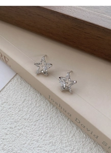 Detailed macro of S999 silver star stud earrings with sparkling cubic zirconia stones
