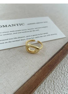 Detailed view of an 18K gold S925 silver hollow oval ring on a textured aesthetic background