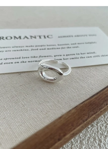Macro detail of S925 sterling silver adjustable oval hollow ring on linen texture
