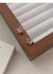 Detailed close-up of S999 sterling silver star stud earrings with pave zircon crystals
