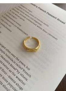 Macro shot of gold octagram star engraving on minimalist rectangular open ring