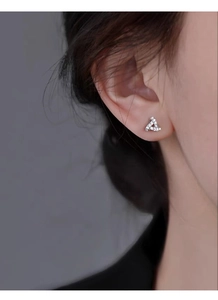 Macro detail of geometric triangle stud earring featuring sparkling micro-pave zircons