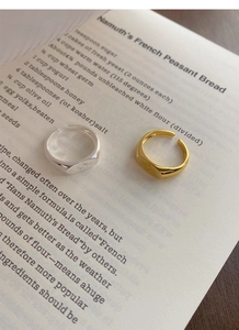 Detail of square signet rings with starburst engraving on vintage book pages