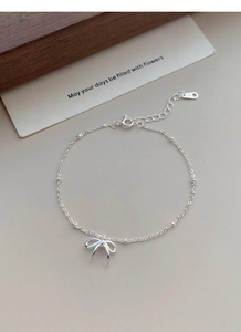 Dettaglio del bracciale in argento S925 con fiocco, catena regolabile e marchio del metallo