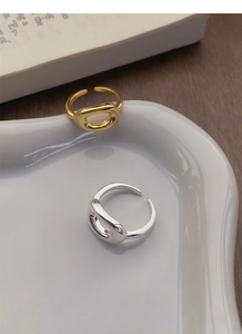 Macro detail of gold and silver S925 oval rings on a white plate showing fine polishing