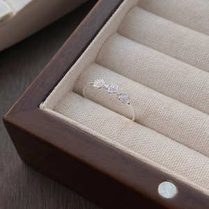 Minimalistischer S925 Sterlingsilber Ring mit drei kleinen Pflaumenblüten in einer Box