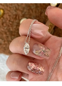 Close-up of sparkling marquise-cut solitaire pendant on a delicate silver link chain