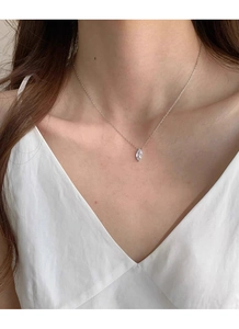 Close-up of a marquise-cut zircon pendant on a delicate S925 silver chain worn by a model