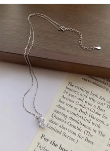 Macro shot of S925 sterling silver marquise necklace with sparkling zircon on a vintage book
