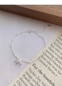 Dettaglio del bracciale in argento sterling S925 con fiocco, catena a sfere e chiusura a moschettone