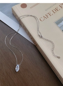 Detail of S925 silver necklace with marquise-cut zircon on a French style book