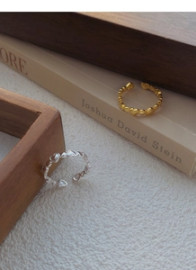 Detail of adjustable S925 silver open rings featuring hollow heart patterns in gold and silver