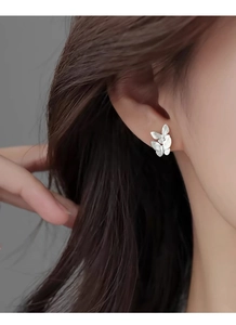 Detailed close-up of S999 silver butterfly stud earrings with matte brushed finish on ear