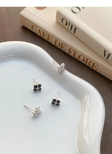 Macro detail of S999 silver four-leaf clover earrings with black and white zircon