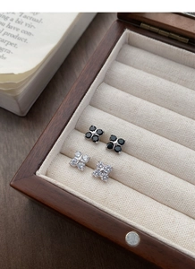 Detail of S999 sterling silver clover stud earrings with black and white zircon stones