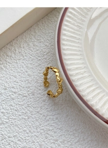 Detail view of adjustable gold heart ring featuring a sequence of small linked hearts