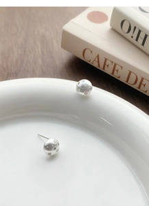 Macro detail of S925 sterling silver starburst earrings with a brushed matte finish