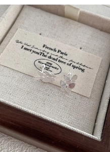 Detailed close-up of S999 sterling silver butterfly stud earrings in a wooden jewelry box