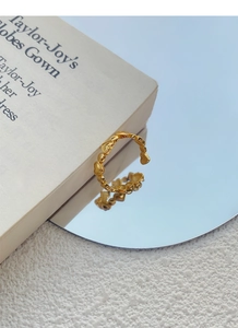 Detailed close-up of golden heart-shaped linked ring reflecting on a mirror surface
