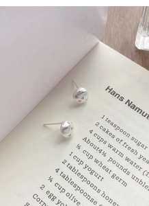 Detailed macro view of S925 sterling silver star earrings with brushed matte metal texture