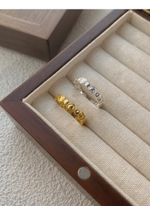 Detail of interlocking silver and gold heart rings in a luxury velvet jewelry box