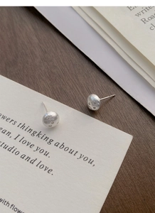 Macro view of matte S925 sterling silver starburst stud earrings with zircon stones