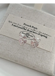 Macro shot of S999 sterling silver butterfly stud earrings with brushed metal texture