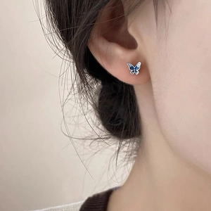 Orecchini a farfalla blu minimalisti in argento sterling S999 su una modella