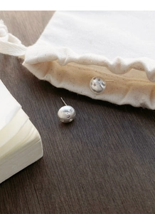 Macro shot of silver ball studs with brushed finish and starburst crystal inlays