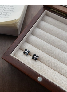 Macro shot of S999 sterling silver clover earrings with black zircons in a jewelry box