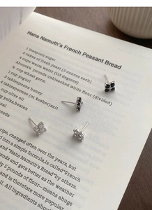 Macro detail of S999 sterling silver four-leaf clover stud earrings with black and white zircon