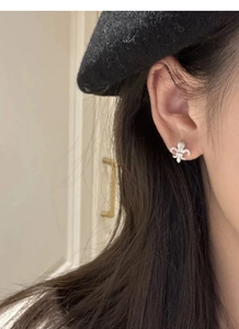 Close-up of S925 sterling silver fleur-de-lis stud earrings with zircon on a model