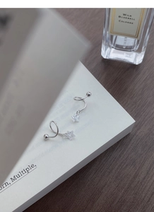 Dettaglio dell'orecchino a stella in argento S925 con perno a spirale dal design unico
