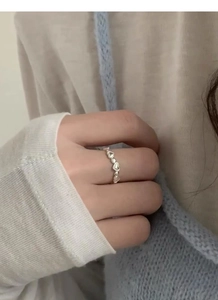 Close-up of S925 sterling silver heart-shaped beaded ring worn on female finger