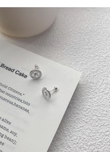 Detailed close-up of S999 sterling silver button earrings with twisted rope texture edges