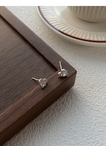 Detailed macro view of S999 sterling silver heart-shaped bow earrings with zircon stones