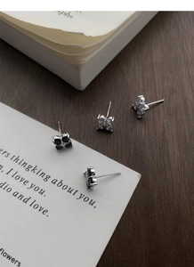 Close-up of black and white zircon clover stud earrings in S999 sterling silver