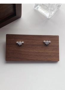 Macro detail of S999 sterling silver stud earrings with three sparkling zircons