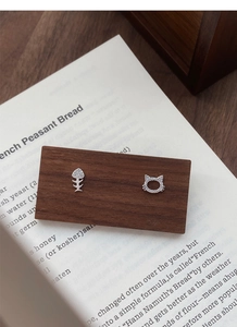Detail of asymmetric S999 silver cat and fish bone stud earrings with zircon inlay