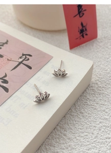 Close-up of S999 sterling silver lotus earrings with frosted and polished textures