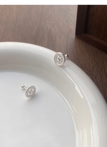 Macro view of S999 silver button stud earrings with textured rope edge and screw back
