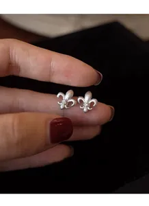 Macro view of brushed S925 sterling silver iris stud earrings with micro-inlaid rhinestones