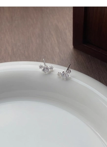 Macro detail of S999 silver stud earrings with sparkling round zircon in star cluster style