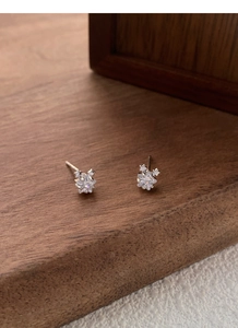 Gros plan sur des boucles d'oreilles étoile en argent S999 avec un zircon central