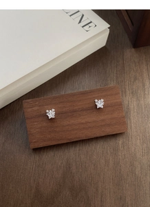 Détail macro des boucles d'oreilles étoiles en argent S999 avec zircone brillante