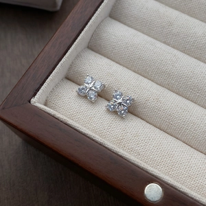 Minimalist S999 sterling silver clover stud earrings with zircon on a velvet jewelry box