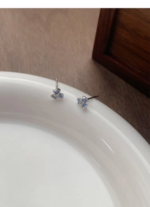 Détail macro de boucles d'oreilles iris bleu en argent S925 avec zircon central