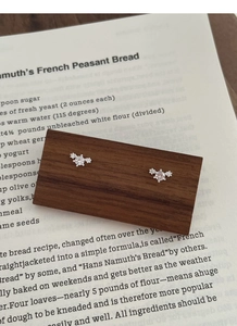 Detail of S999 sterling silver stud earrings with sparkling cubic zirconia on wood